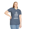 Model wearing Keep Calm Softstyle T-Shirt in blue with 'Keep Calm and Play Hand & Foot Remastered' printed on front.