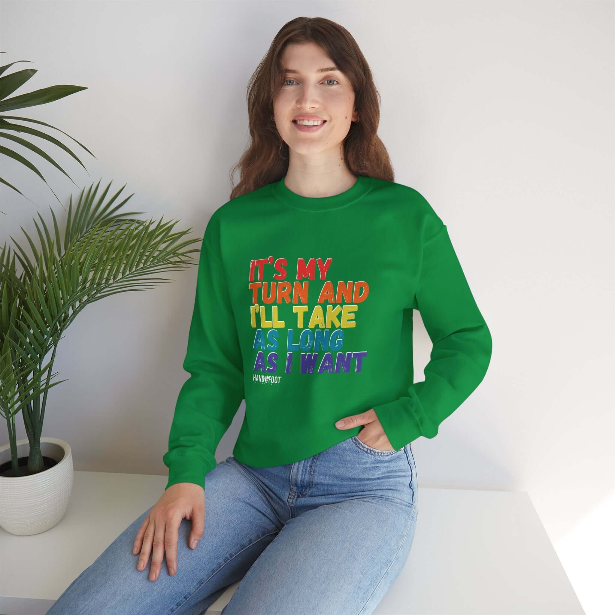 Unisex green crewneck sweatshirt with 'It's My Turn' text, worn by a smiling person; casual style.
