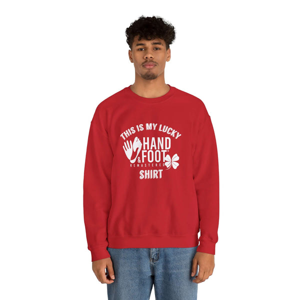 Man wearing red Lucky Unisex Heavy Blend Crewneck Sweatshirt with hand and foot graphic design.