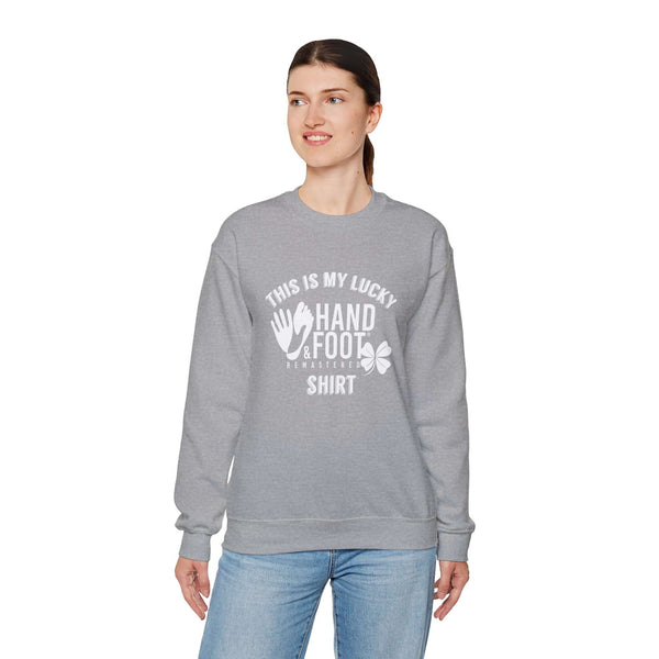Woman wearing a gray Lucky Unisex Heavy Blend Crewneck Sweatshirt with "This is My Lucky Hand & Foot Shirt" print, casual style.