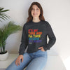 Person wearing It's My Turn Unisex Heavy Blend Crewneck Sweatshirt with colorful text, sitting on a bench next to a plant.