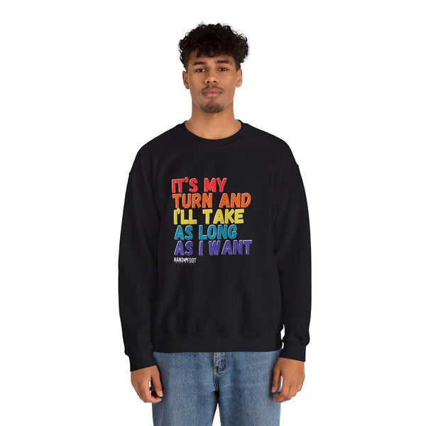 Man wearing 'It's My Turn' black unisex crewneck sweatshirt with colorful text, relaxed fit.