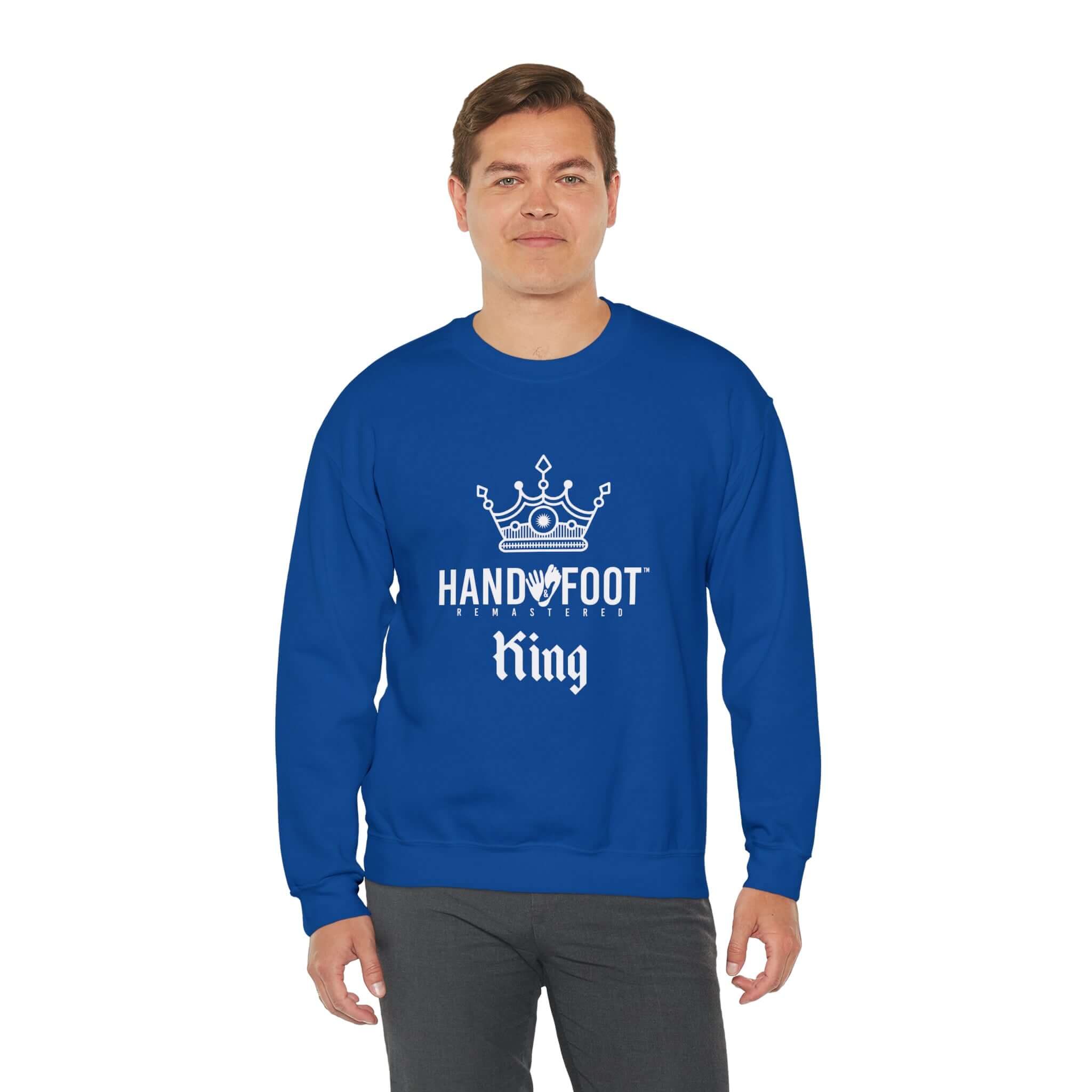 Man wearing blue Hand & Foot King Unisex Heavy Blend Crewneck Sweatshirt with crown logo, promoting comfort and sustainable fashion.