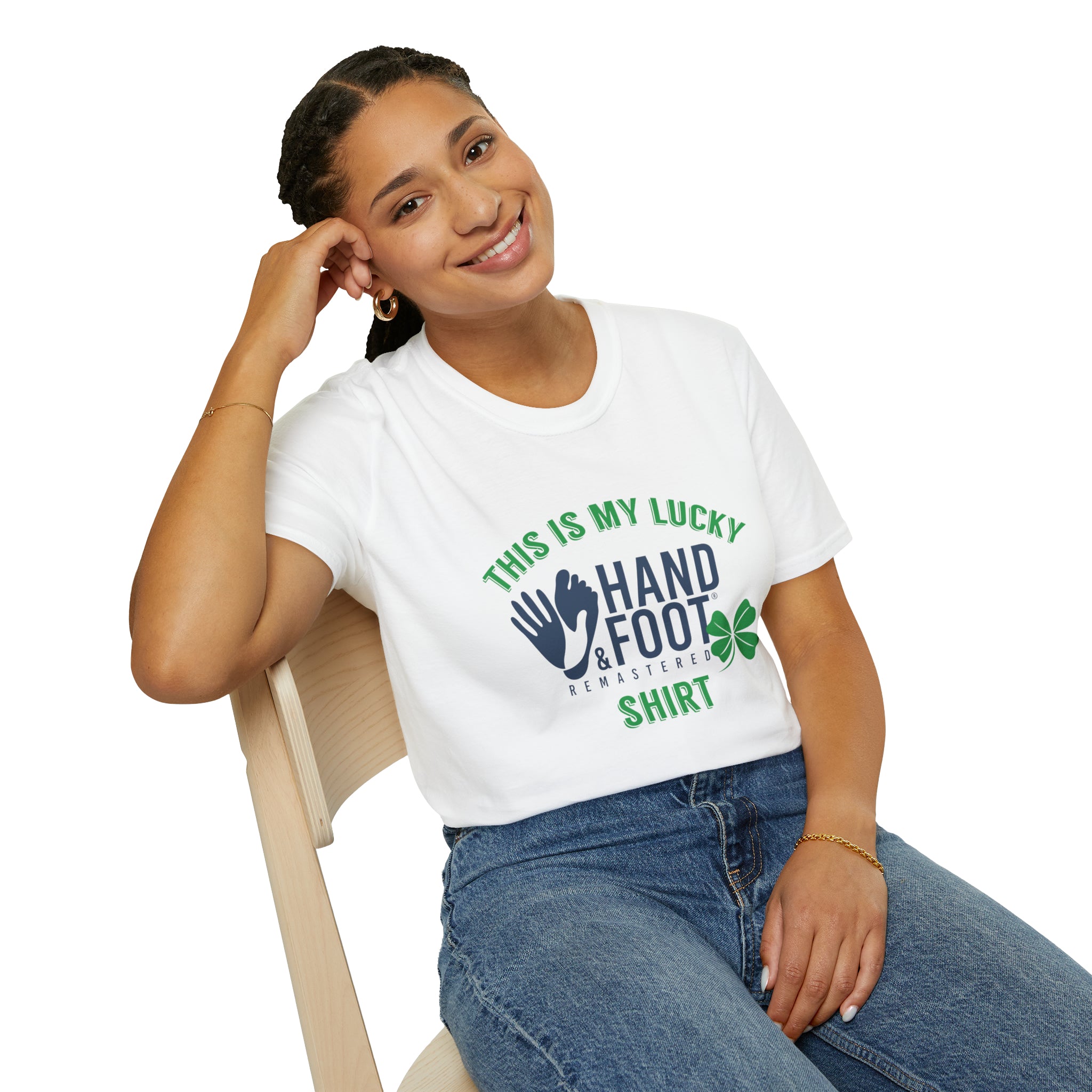 Woman wearing a white Lucky Softstyle T-Shirt with green and blue print, sitting on a chair, smiling.