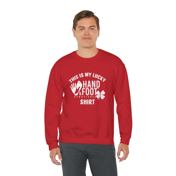 Person wearing a red Lucky Unisex Heavy Blend Crewneck Sweatshirt, featuring a playful hand and foot design with text.