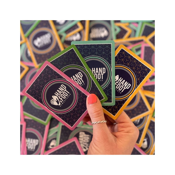 Colorful Hand & Foot Remastered cards in a hand, showcasing the game expansion for up to 8 players.