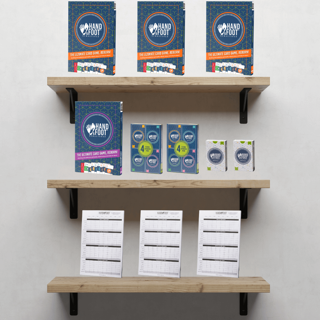 Hand & Foot Remastered Retail Starter Pack displayed on wooden shelves, featuring game editions, score pads, and action packs.