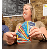 Woman enjoying a game of Hand & Foot Remastered, holding colorful game cards and smiling in a lively setting.