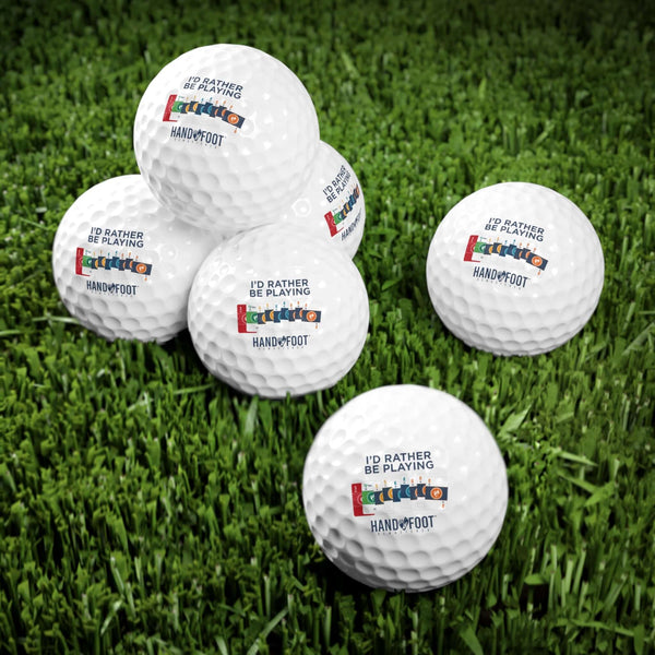 Set of premium golf balls with 'I'd Rather Be Playing Hand & Foot' design on a grassy surface.