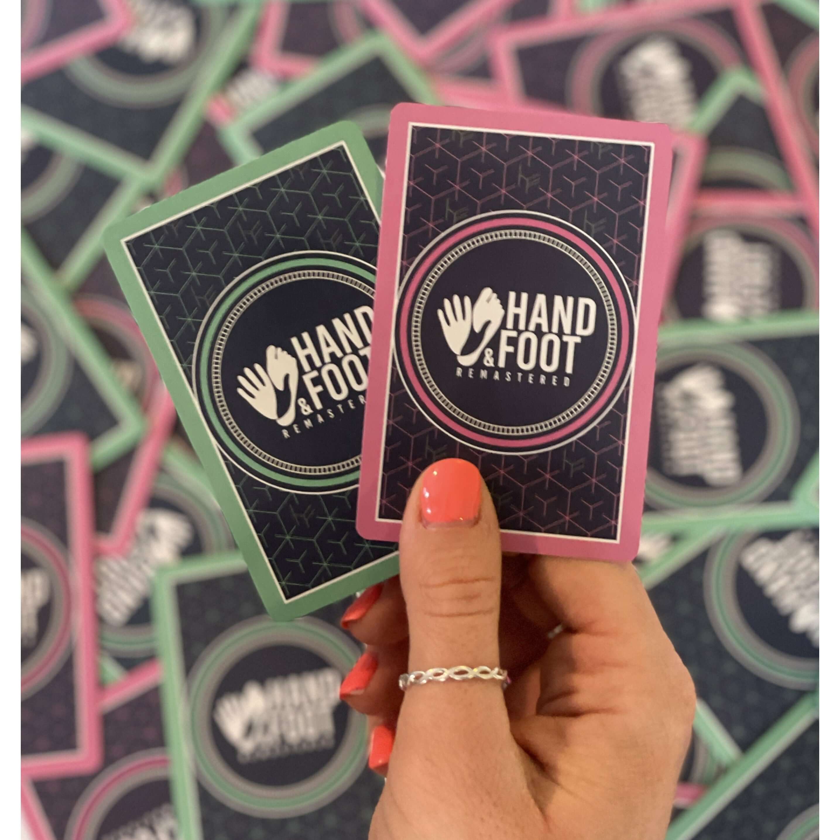 Hand holding Hand & Foot Remastered Expansion Pack cards with original finish for extended gameplay up to 8 players.