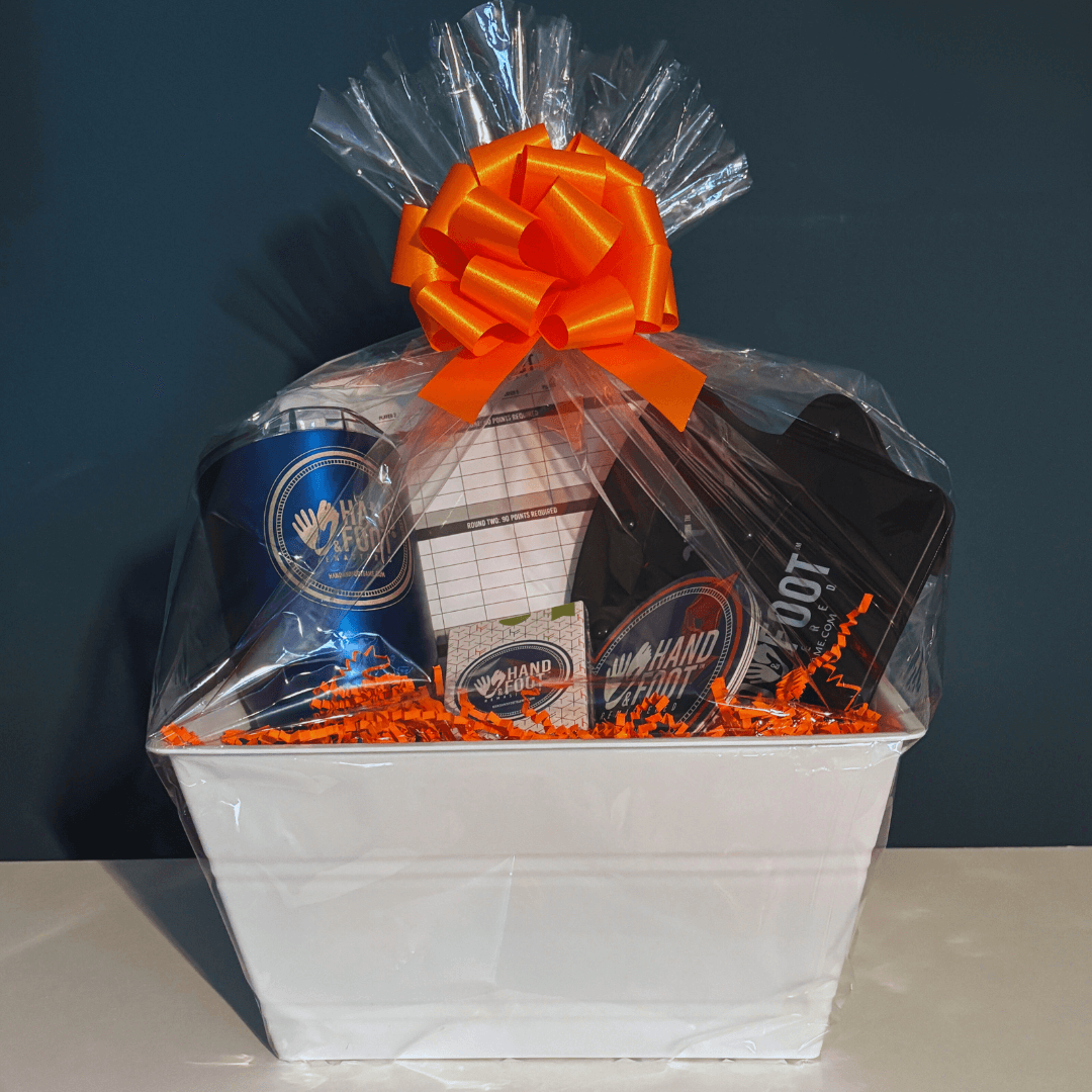 Limited-Edition Hand & Foot Remastered Accessory Set gift basket wrapped with bright orange bow, perfect for game enthusiasts.