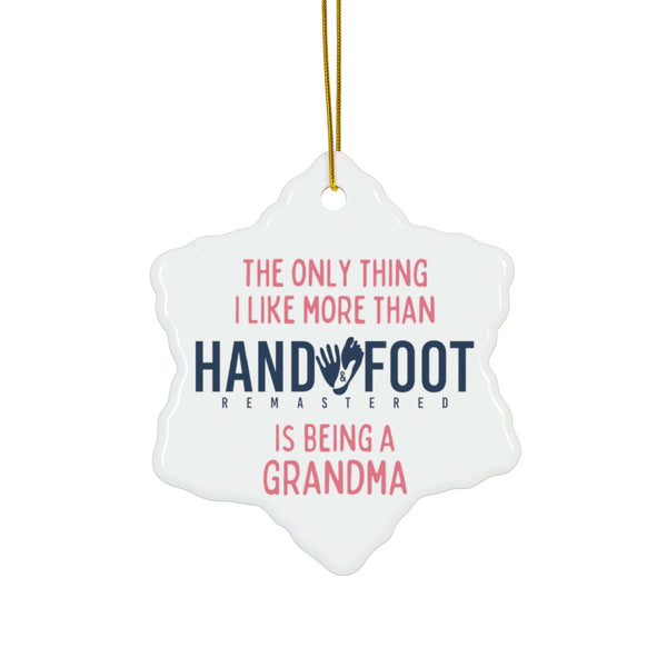 Snowflake-shaped ceramic ornament with 'The only thing I like more than Hand & Foot is being a Grandma' text, suitable for Christmas decoration.