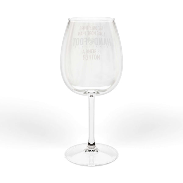 Being a Mother hand and foot wine glass with etched text highlighting motherhood on transparent glass.