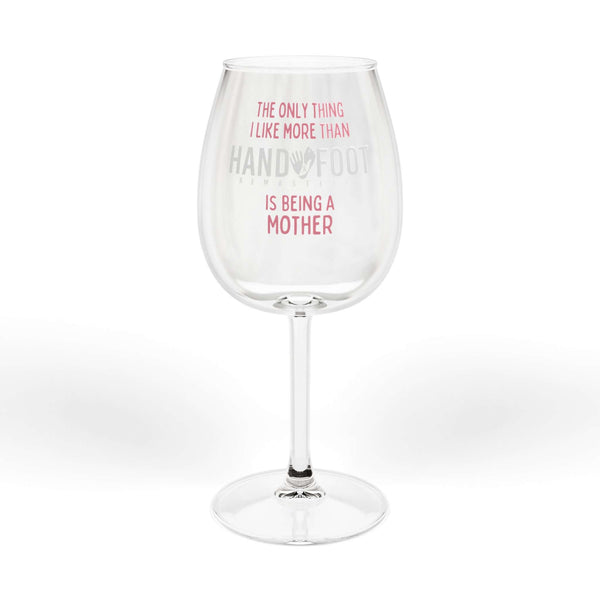 Wine glass with "Being a Mother" and "Hand & Foot" text, suitable for gifts. Clear glass design, perfect for wine lovers.