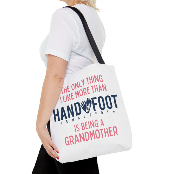 Woman holding Being a Grandmother Hand & Foot Remastered Tote Bag with black handles
