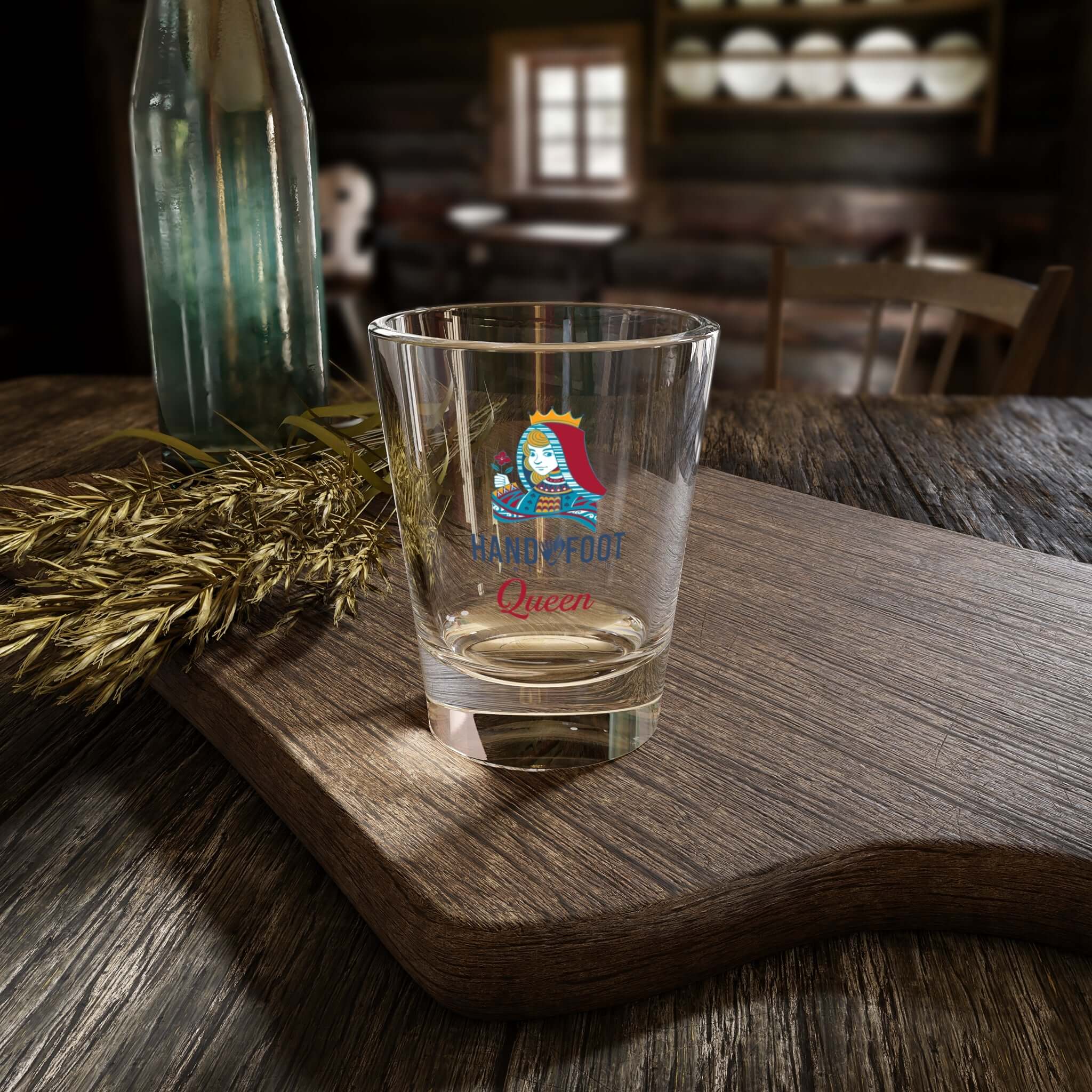 Hand & Foot Queen Shot Glass on wooden table in cozy setting, perfect for parties and celebrations.