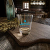 Shot glass with 'Tears of the People I Beat' text, ideal for parties and collections, sitting on a rustic wooden table.