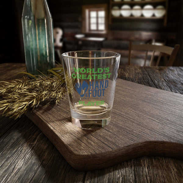 World's Greatest Player Shot Glass on wooden table, perfect for parties, barware, and special occasions.